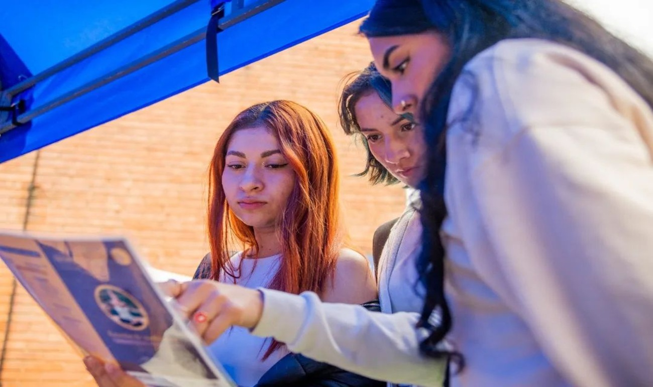 Tres mujeres revisando un libro