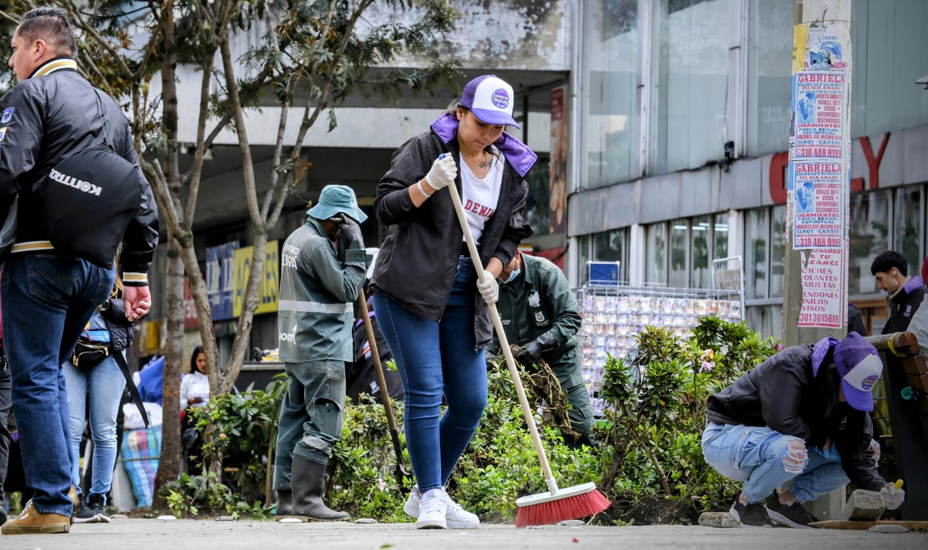 Persona barriendo la calle