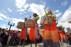 Mujeres en zancos tocan instrumentos