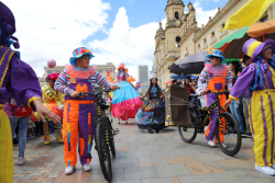 Niño de comparsa con bicicleta en mano