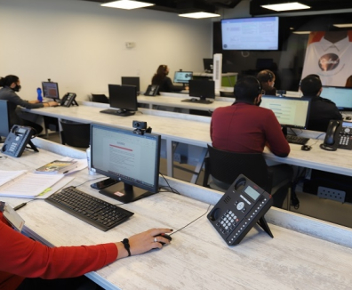 Personas trabajando frente a computadores en la Línea Calma