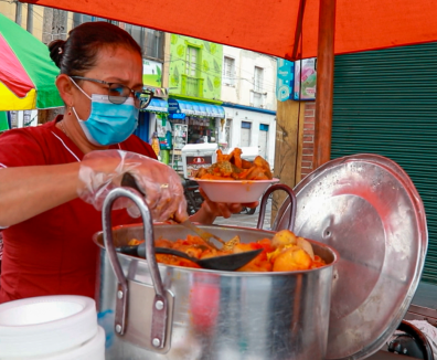 Mujer siviendo comida | Bogotá Comensal