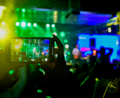persona tomando una foto a un espectáculo musical