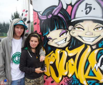 Pareja de hombre y mujer al lado de un mural