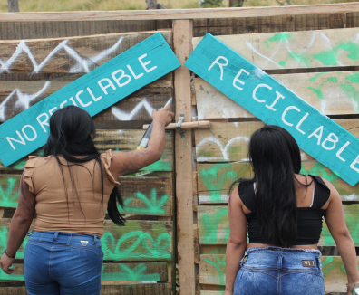 Dos mujeres mirando un letreoro que dice Reciclaje