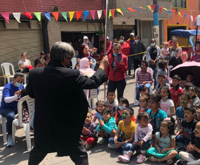 Mago haciendo una presentación frente a un grupo de niños y niñas
