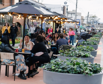 Personas reunidas en mesas en la calle