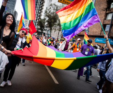 Personas marchando con bandera LGBTI