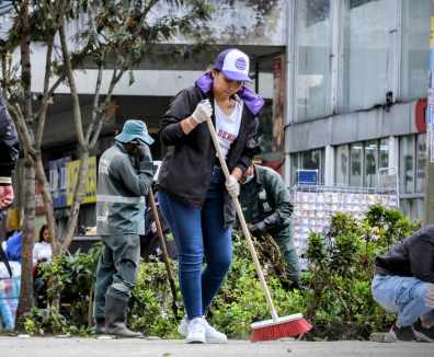Persona barriendo la calle