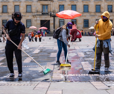 Personas barriendo la Plaza de Bolívar