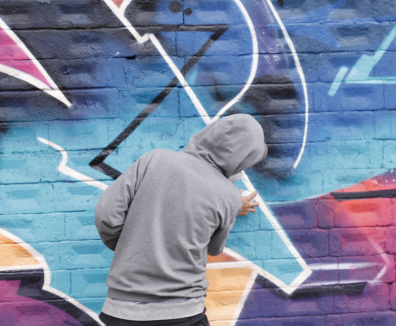 Joven grafitero pintando un mural