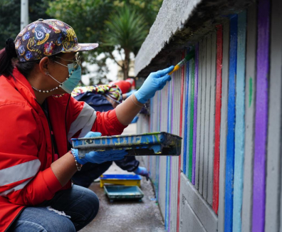 Mujer pintando una calle de Bogotá en jornada del Centro Vive