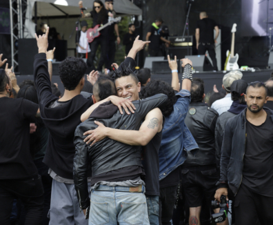 Personas en concierto de rock, abrazándose