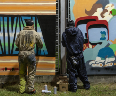dos jovenes pintando grafiti en Bogotá