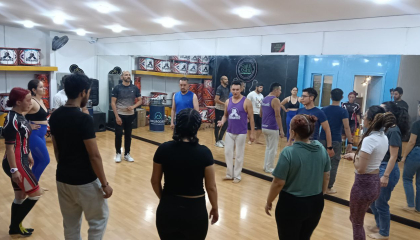 Fotografía de un taller con varias personas en un salón de espejos