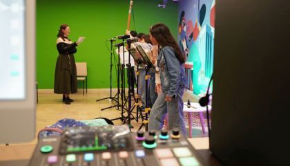 Fotografía de varias niñas y niños grabando su voz en un estudio de grabación