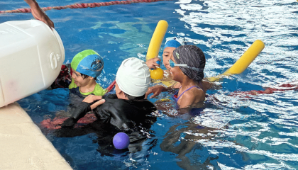 Fotografía de niñas y niños en actividad recreativa en la psicinas