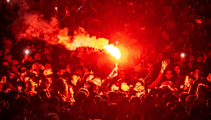 Fotografía de una multitud con una bengala en la mano