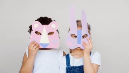 Fotografía de dos niños con máscaras de papel 