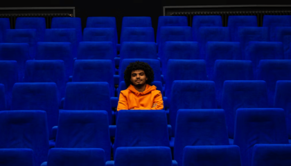 Una persona sentada en medio de una sala de cine