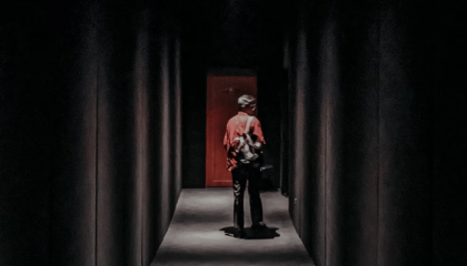 Persona en la mitad de un pasillo con iluminación damática