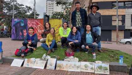 Participantes del taller con sus acuarelas al frente.