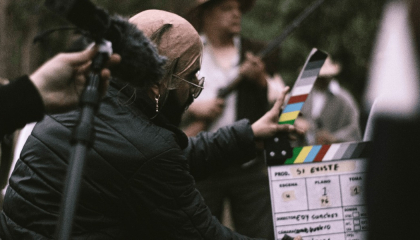 Personaje con una claqueta de cine, iniciando una escena.               