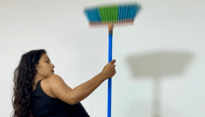 Mujer sosteniendo una escoba en lo alto