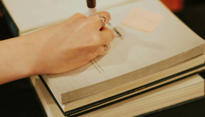 Persona escribiendo en un libro.