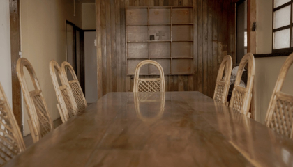 Imagen de sillas artesanales alrededor de una mesa de madera.