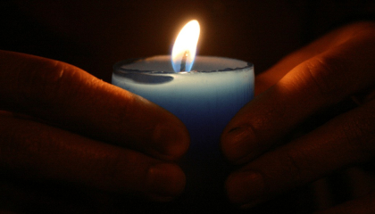 manos sosteniendo una vela encendida