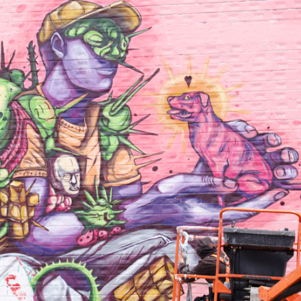 Arte urbano de un perro y una persona en una pared