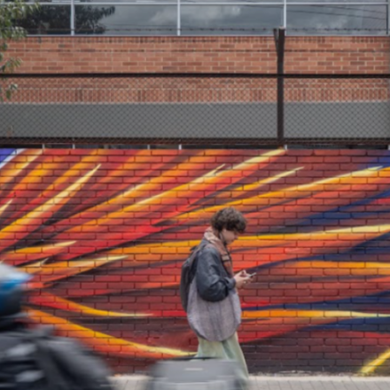 persona caminado en la calla con grafiti al fondo
