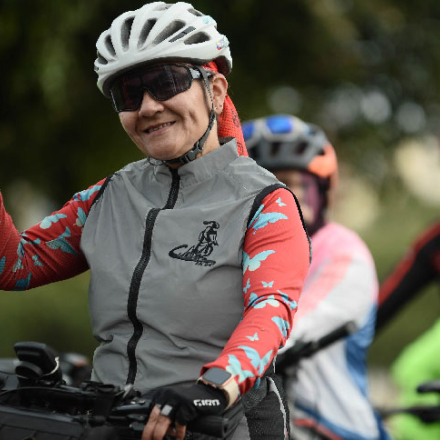 Mujer en bicicleta saludando a la cámara