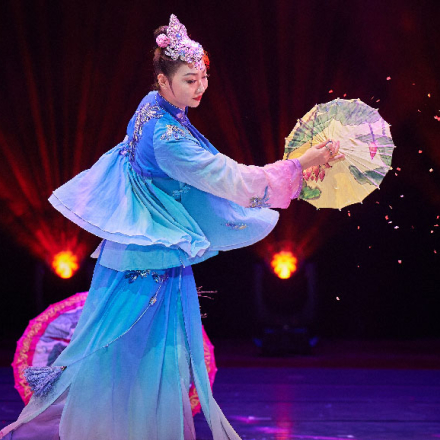 mujer china en un escenario con traje típico