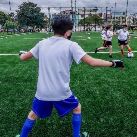 Niñas y niños jugando fútbol