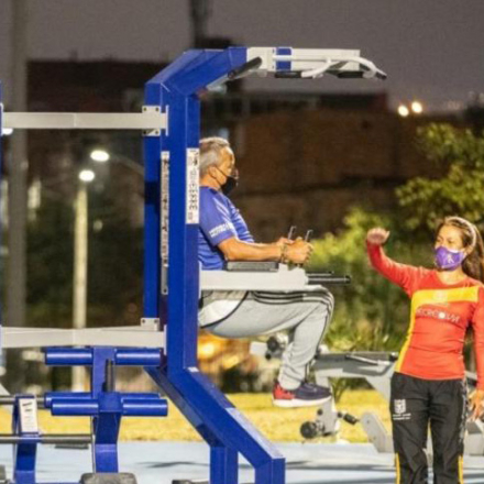 Persona mayor usando máquinas de gimnasio al aire libre