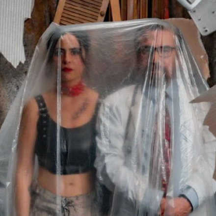 una pareja elegante detrás de un plástico transparente