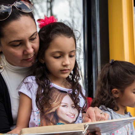 Madre e hija leyendo un libro en una biblioteca