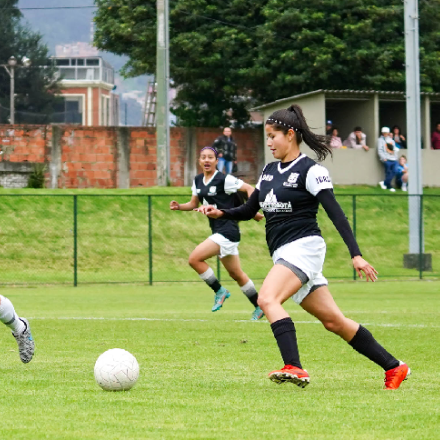 Mujeres jugando fútbol en una cancha