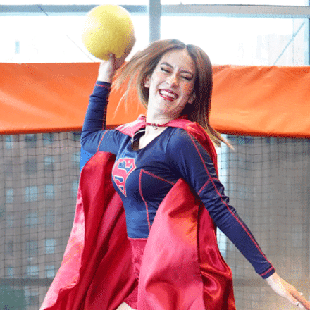 Mujer disfrazada saltando y con una pelota en la mano