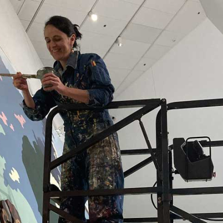 mujer realizando una pintura en una pared