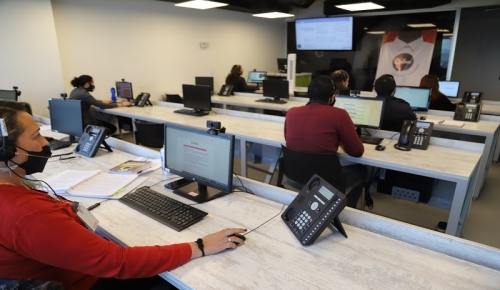 Personas trabajando frente a computadores en la Línea Calma