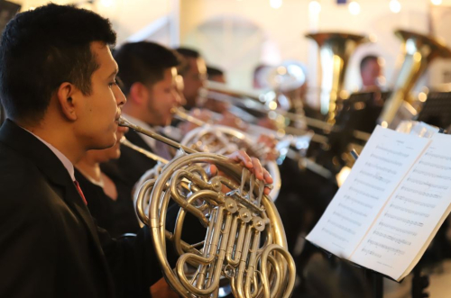 hombre tocando un instrumento musical mientras lee una partitura