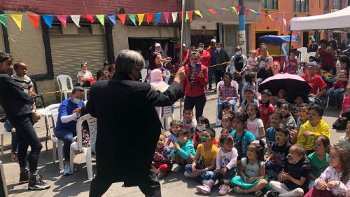 Mago haciendo una presentación frente a un grupo de niños y niñas