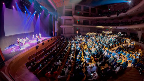 Multitud de personas en un teatro observando una presentación artística