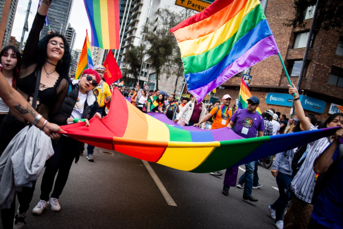 Personas marchando con bandera LGBTI