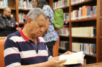 persona mayor leyendo en una biblioteca