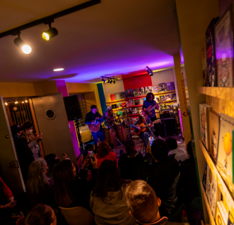 Personas reunidas en un recinto cerrado escuchando un concierto en vivo