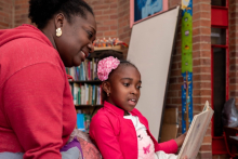 Madre e hija leyendo en una biblioteca